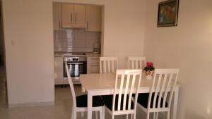 a kitchen with a table and chairs and a kitchen with a stove at House Racic in Bol