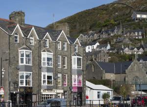 un gran edificio de ladrillo con una colina en el fondo en Harbour View - Flat 2, en Barmouth