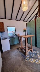 a room with a table with a vase of flowers on it at Apartamento do Manu in Atins