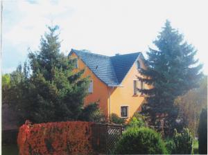 a house with a blue roof and some trees at Apartment Zum Keulenbergblick in Laußnitz
