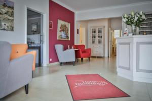 Hotel Dünenburg في فيسترلاند: غرفة معيشة بجدران حمراء وسجادة حمراء