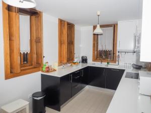 a kitchen with black cabinets and white counter tops at Casa da Gandarela in Soajo +20 photos