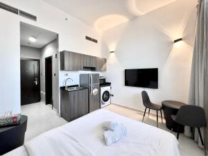 une chambre avec un lit et une cuisine avec une télévision dans l'établissement Al Manara Classic Deluxe Sheikh Zayed Studio, à Dubaï