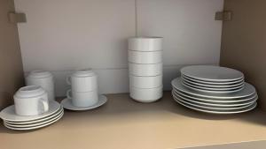 a stack of plates and cups sitting on a shelf at Malia Beach Porto Galinha By Loui in Ipojuca +11 photos