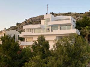 a white house on top of a hill with trees at Luxury Villa in Altea Hills in Altea