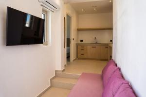a living room with a flat screen tv on a wall at Wabi Aegean Villa in Ios Chora