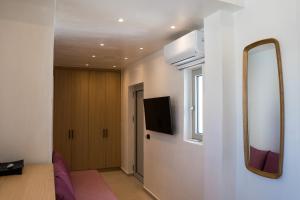 a living room with a tv and a mirror at Wabi Aegean Villa in Ios Chora
