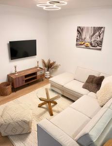 a living room with a white couch and a flat screen tv at Scandi Apartment with Terrace and Parking in Karlsruhe