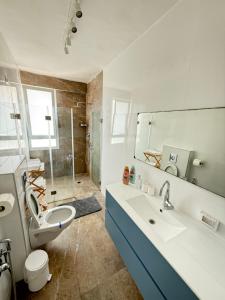 a bathroom with a sink and a toilet and a mirror at Sweet apartment in Netanya +5 photos