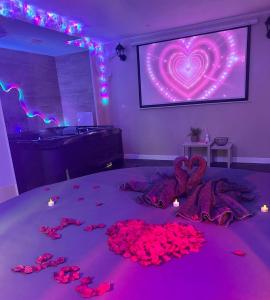 a bed with a pile of red roses on it at Loft Paradis ~Jacuzzi privatif~ Séjour amour in Vieille-Toulouse