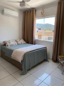 um quarto com uma cama e uma janela grande em Casa 2 Suites, Niterói Região Oceanica em Niterói