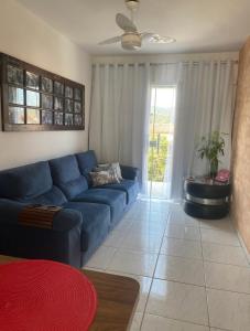 uma sala de estar com um sofá azul e uma janela em Casa 2 Suites, Niterói Região Oceanica em Niterói