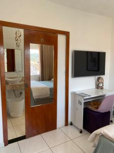 um quarto com uma porta que leva a um quarto com uma cama em Casa 2 Suites, Niterói Região Oceanica em Niterói