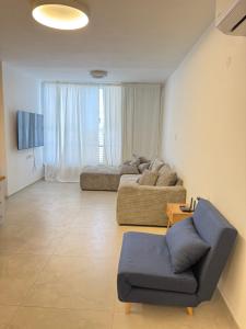 a living room with a couch and a chair at Sweet apartment in Netanya