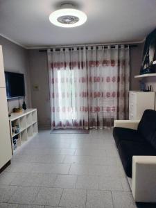 a living room with a couch and a television at Casa Antony in San Teodoro