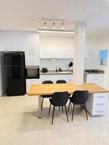 a kitchen with a wooden table and four chairs at Sweet apartment in Netanya