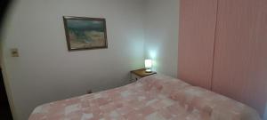 a bedroom with a bed and a lamp on a table at Apartamento Edificio Niza Península Se Reserva con SEÑA in Punta del Este
