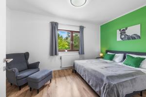 a green bedroom with a bed and a chair at NA-Home Melcherhof in Grafenstein