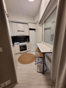 a small kitchen with white appliances and a table at Studio from Downtown with Sauna in Kuusamo