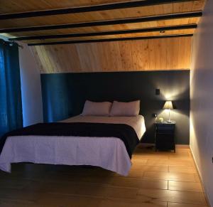 a bedroom with a large bed with a wooden ceiling at Monteluna Fraijanes in Poasito