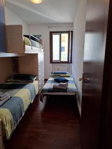 two beds in a small room with a window at Appartamento in Centro Storico - A due passi dalle Mura in Castelfranco Veneto