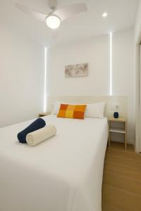 ein weißes Schlafzimmer mit einem großen weißen Bett und einem Tisch in der Unterkunft Cómodo apartamento en Madrid climatizado in Madrid