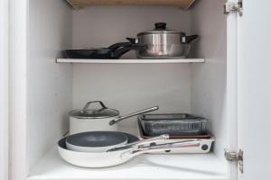 a kitchen shelf with a pot and pans on it at Assembly Hall Hideaway - Walk to Stadiums! in Bloomington
