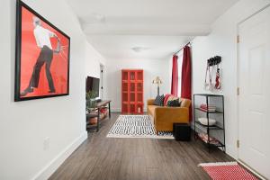 a living room with a couch and a painting on the wall at Assembly Hall Hideaway - Walk to Stadiums! in Bloomington