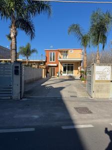 a building with a palm tree in front of a street at Luxury Room Home Serpico in Scisciano