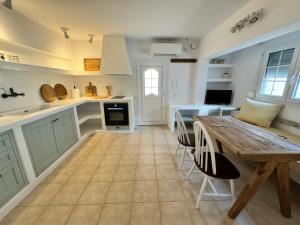 a kitchen with a wooden table and a dining room at Leonidas House Renovated 2024 in Agia Marina