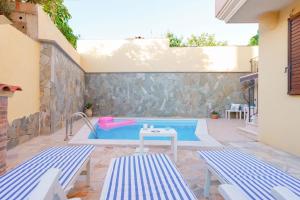 a swimming pool with two blue and white benches at exclusive use swimming pool available from June to September in Cagliari