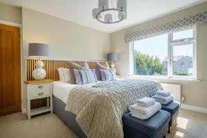 a bedroom with a bed and a window with towels at The Bank House in Silverdale