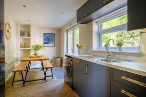 a kitchen with a sink and a table and a window at The Bank House in Silverdale