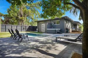 a patio with two chairs and a table and a house at 175 Casa Buena Blanca in Miami