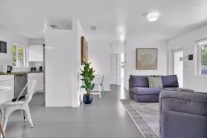 a living room with a purple couch and a kitchen at 175 Casa Buena Blanca in Miami