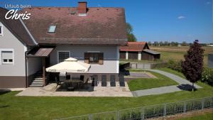 ein Haus mit einem Tisch und einem Sonnenschirm im Hof in der Unterkunft Urlaub beim Chris in Untervogau