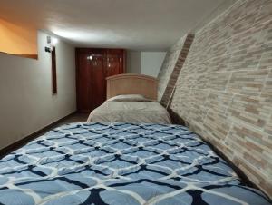 a bedroom with a bed and a brick wall at Hermosos departamentos en el centro de Coatepec Veracruz in Coatepec