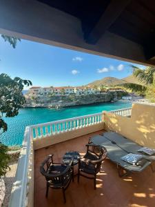 un balcone con tavolo, sedie e acqua di Appartement 8 & 9- Lagun blou resort - Curaçao a Lagun Altre 37 foto