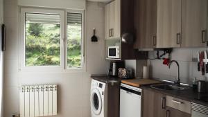 a kitchen with a washing machine and a window at La Loma de San Leonardo in San Leonardo de Yagüe