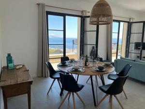 a dining room with a table and chairs and the ocean at Villa Hugo in Brando