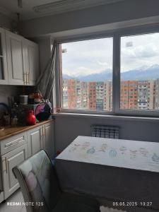 ein Schlafzimmer mit einem Bett und einem großen Fenster in der Unterkunft Жунисова 14 in Zhezdi