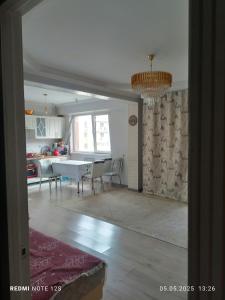 eine Küche und ein Esszimmer mit Tisch und Stühlen in der Unterkunft Жунисова 14 in Zhezdi
