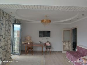 ein Teddybär sitzt auf einem Tisch in einem Wohnzimmer in der Unterkunft Жунисова 14 in Zhezdi