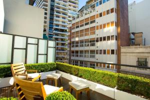 Un balcón con sillas y mesas en un edificio. en Libertad Hotel Buenos Aires, en Buenos Aires
