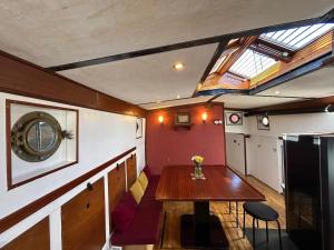 a dining room with a table and a skylight at Hausboot Jonathan in Hamburg