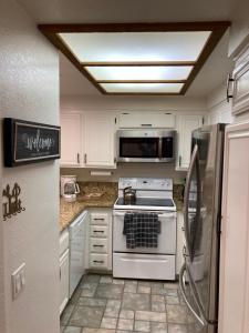 een witte keuken met een fornuis en een koelkast bij Aspen Creek #226 Year-Round Activities in Mammoth Lakes