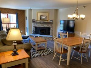 een woonkamer met een bank, een tafel en een televisie bij Aspen Creek #226 Year-Round Activities in Mammoth Lakes