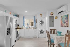 マラソンにあるSeashell Sanctuary 1B 2Ba Pool Clubhouse Elevatorのキッチン(白い家電製品、テーブル、テーブルクロス付)