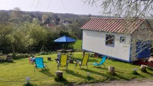 BaincthunTiny House du Pigeonnier的一个带椅子和桌子的院子和房子