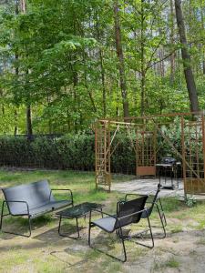 two chairs and a table in a yard with a tent at Domek w lesie in Gnojno